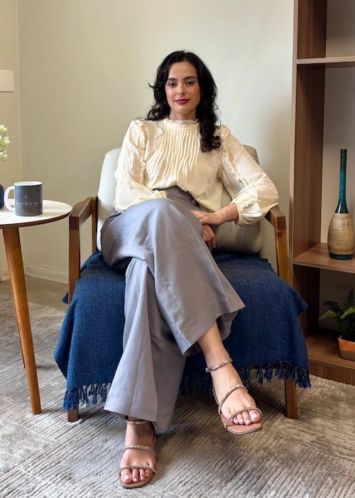 Foto de Thais sentada em seu consultório